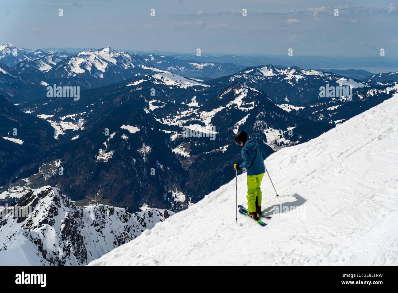Sciatore su pendii ripidi sopra la valle alpina vicino a Nebelhorn Foto Stock