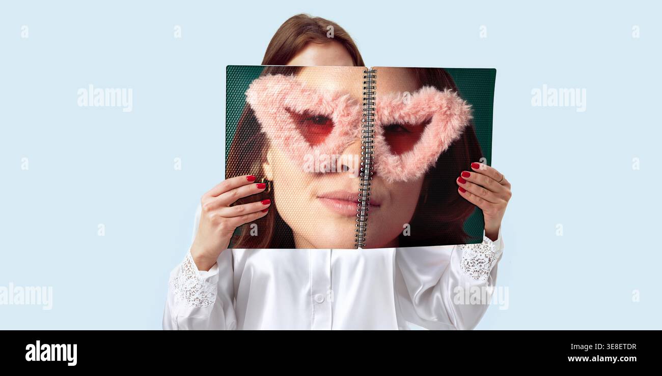 Donna che tiene in mano un notebook con occhiali a forma di cuore per l'app di incontri e l'immagine dei social media. Foto Stock