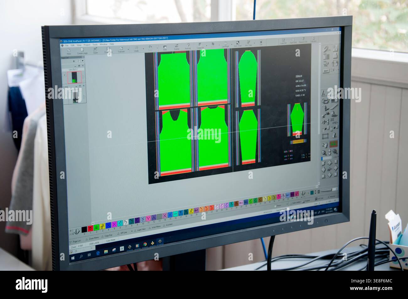 Monitor per computer che mostra il layout dei modelli di indumenti in software di progettazione, utilizzato per la produzione tessile e di abbigliamento, evidenziando la penna ottica digitale Foto Stock