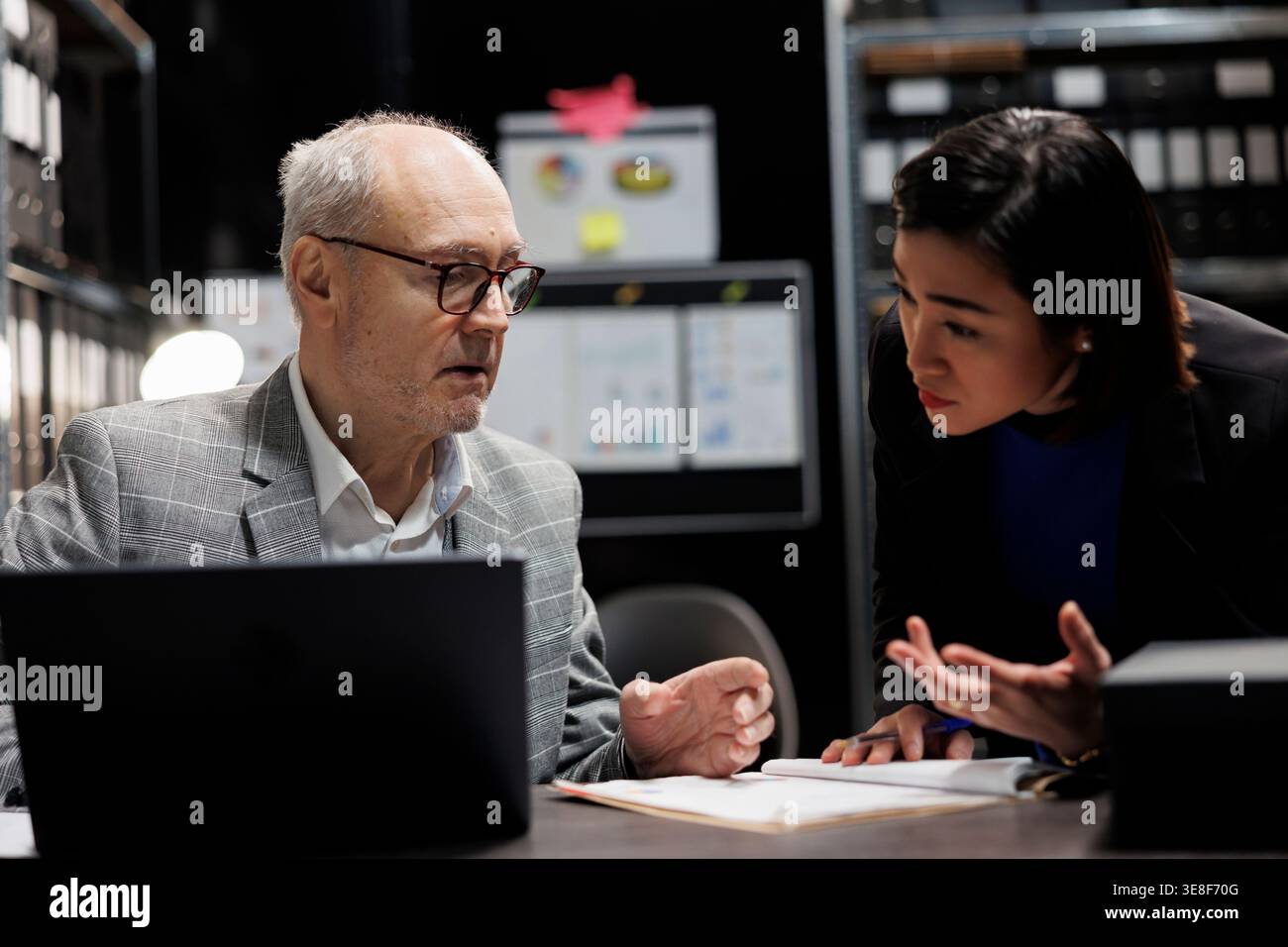 Gestione amministrativa coworking imprenditori che discutono di informazioni relative al database di mercato contabile. Documentazione di fatturazione nell'ufficio dell'armadietto di archiviazione piena di cartelle di documenti e diagrammi di flusso Foto Stock