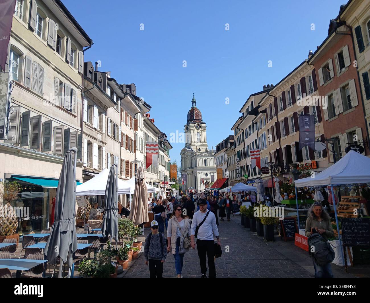 Svizzera Morges - Vista di un vivace mercato di strada con la torre della chiesa nel centro storico della città. Foto Stock