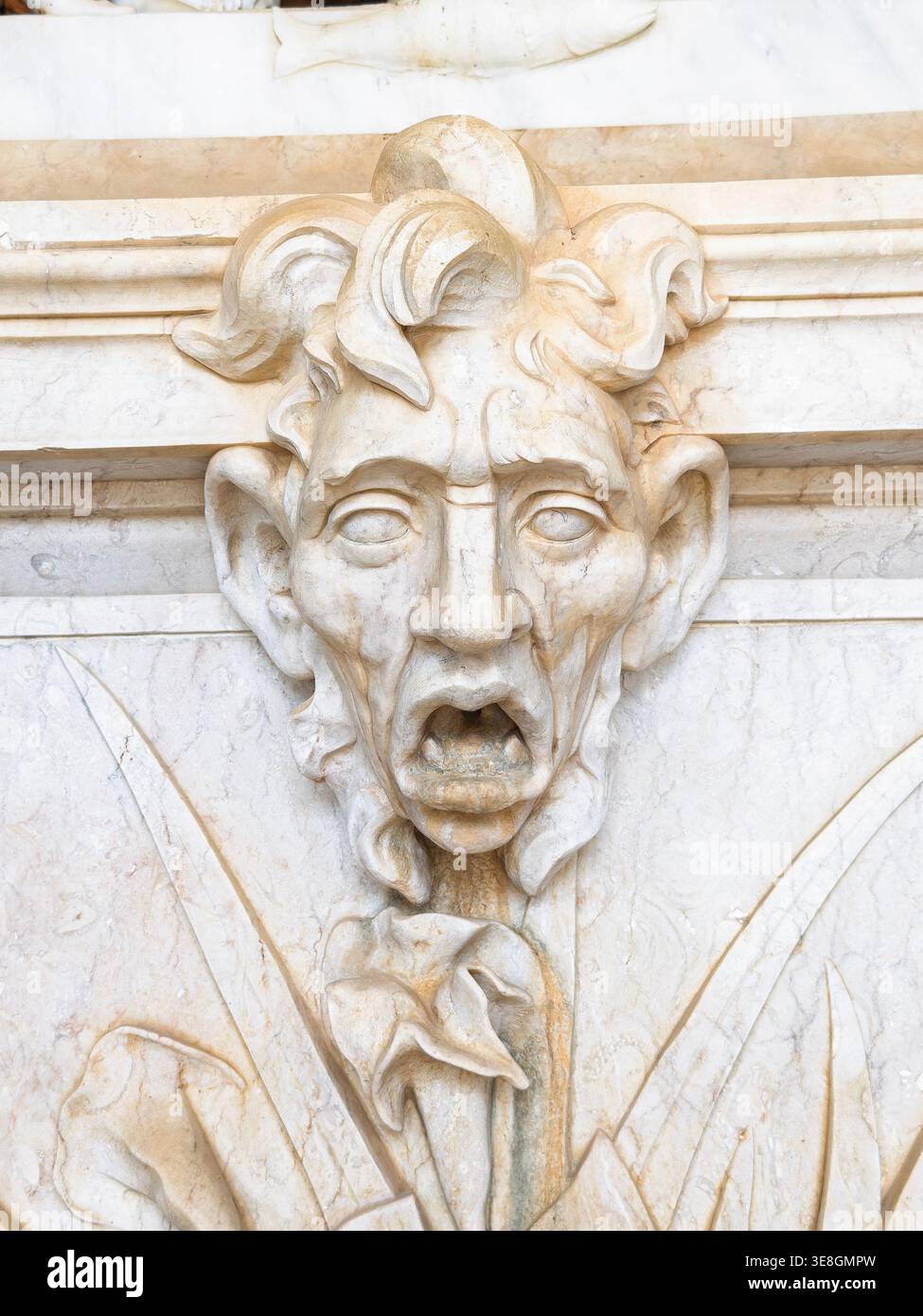 Dettagliata scultura in pietra di un volto grottesco o mascaron su una fontana del palazzo rococò di Estoi nella regione dell'Algarve in Portogallo Foto Stock