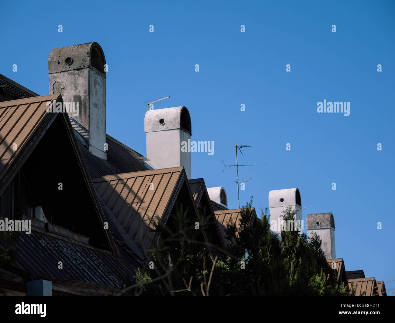 Fila di tetti in metallo con camini in cemento e antenne TV nel distretto di Kristiine, Tallinn, Estonia, primavera Foto Stock