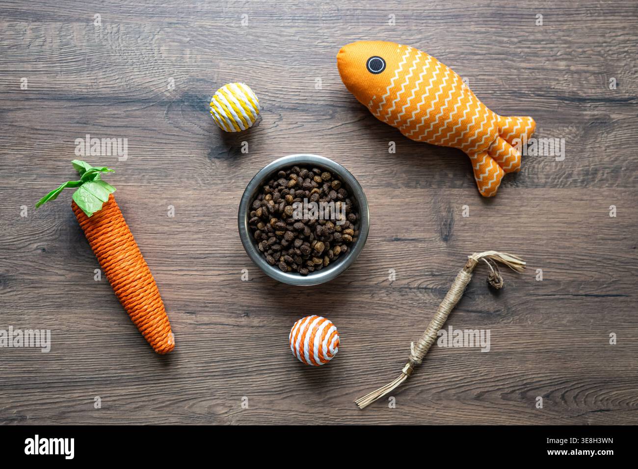 La ciotola per alimenti e i giocattoli Cat sono piatti su sfondo in legno, il concetto di alimentazione e gioco per animali domestici per l'e-commerce e il marketing per l'alimentazione animale Foto Stock