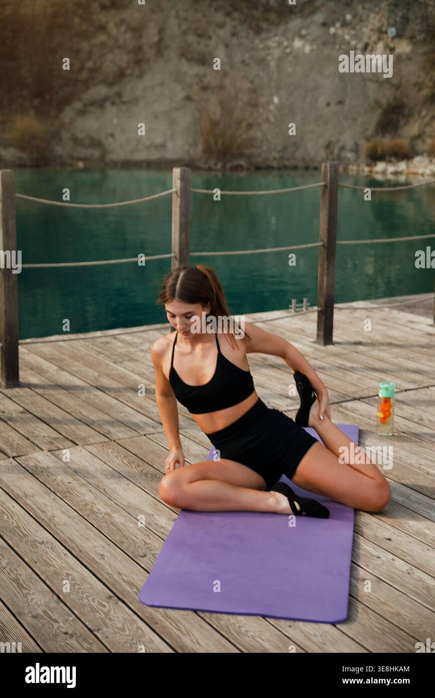 Fitness yoga. Modello femminile con corpo allungato sul tappetino. Donna che si concentra sulla flessibilità e sulla postura. Allenamento all'aperto. Foto Stock