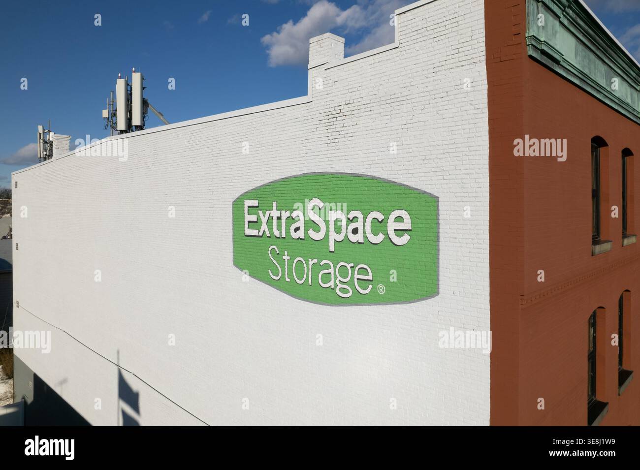 Deposito extra Space con logo verde dipinto sull'esterno di un edificio in mattoni bianchi a Harrison, New Jersey. Foto Stock