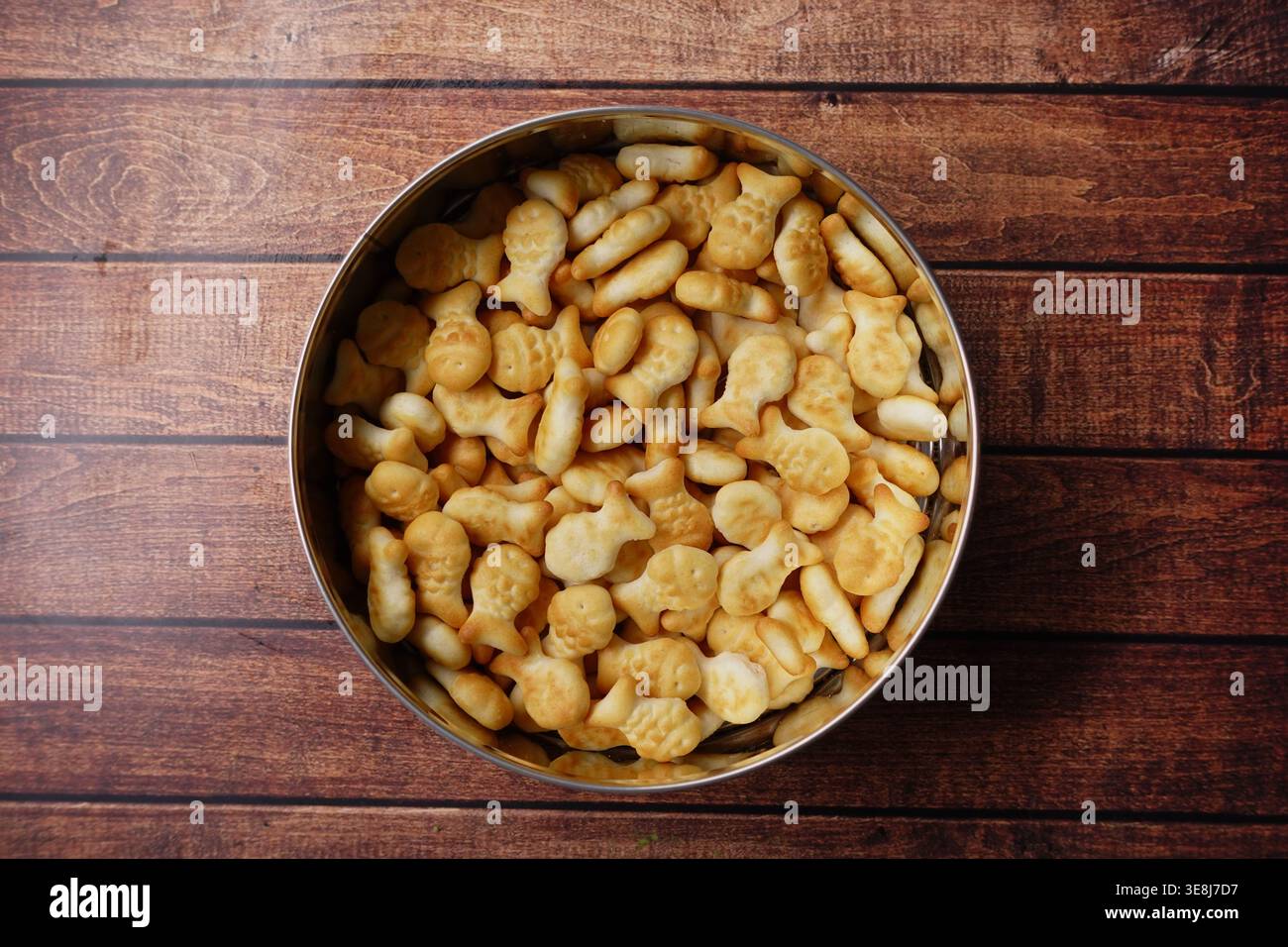 Mescolare gli spuntini in una teglia rotonda di metallo su un tavolo di legno Foto Stock