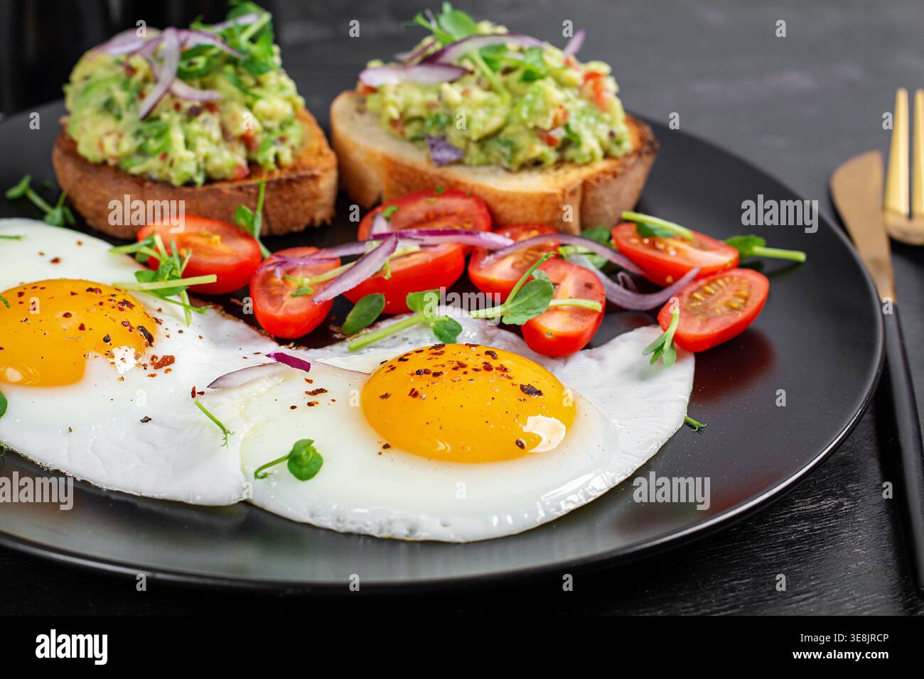 La colazione era pulita e comprendeva pane tostato all'avocado, uova e verdure fresche Foto Stock