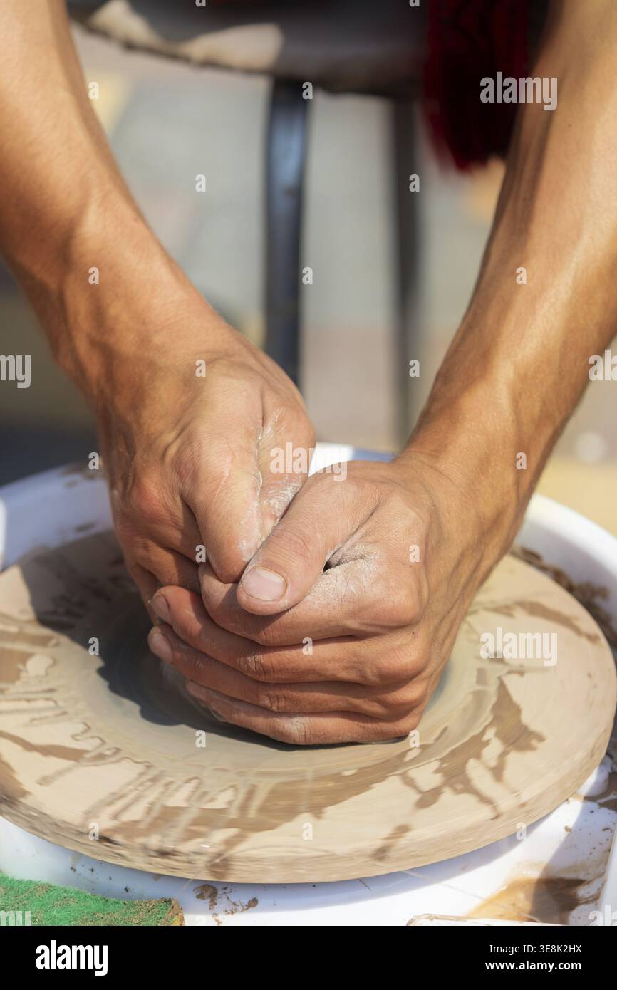 Primo piano delle mani insensibili di un maestro vasaio al lavoro Foto Stock
