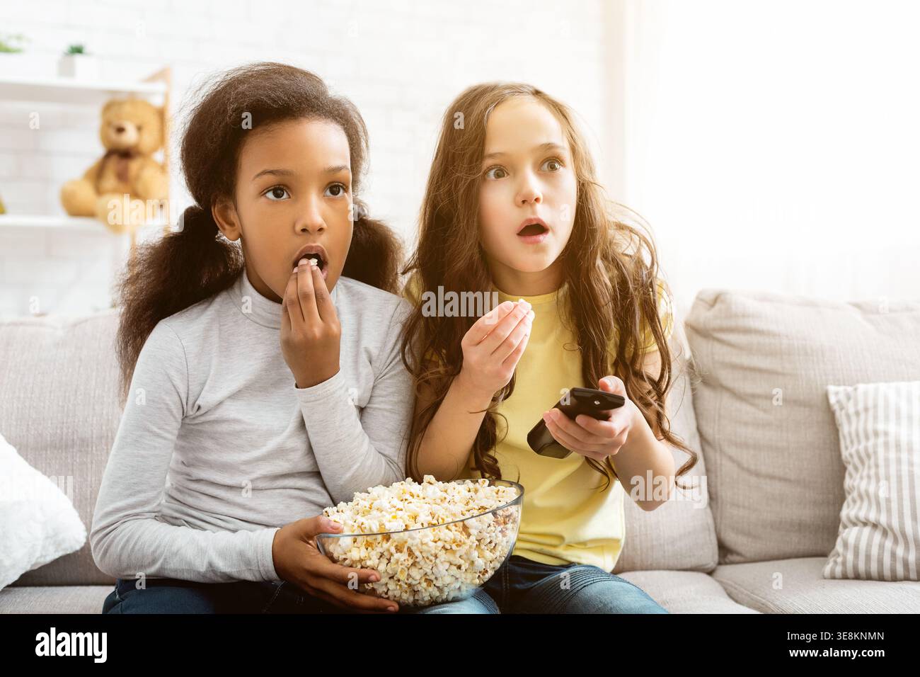 I bambini guardano il canale Discovery e mangiano popcorn Foto Stock