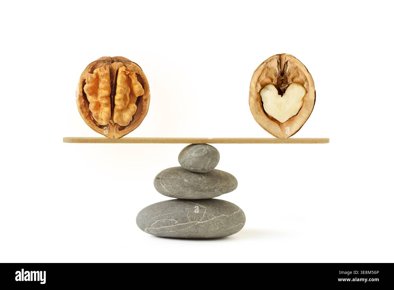 Bilancia in pietra zen con noci a forma di cervello e cuore - concetto di benessere e equilibrio tra cuore e cervello Foto Stock