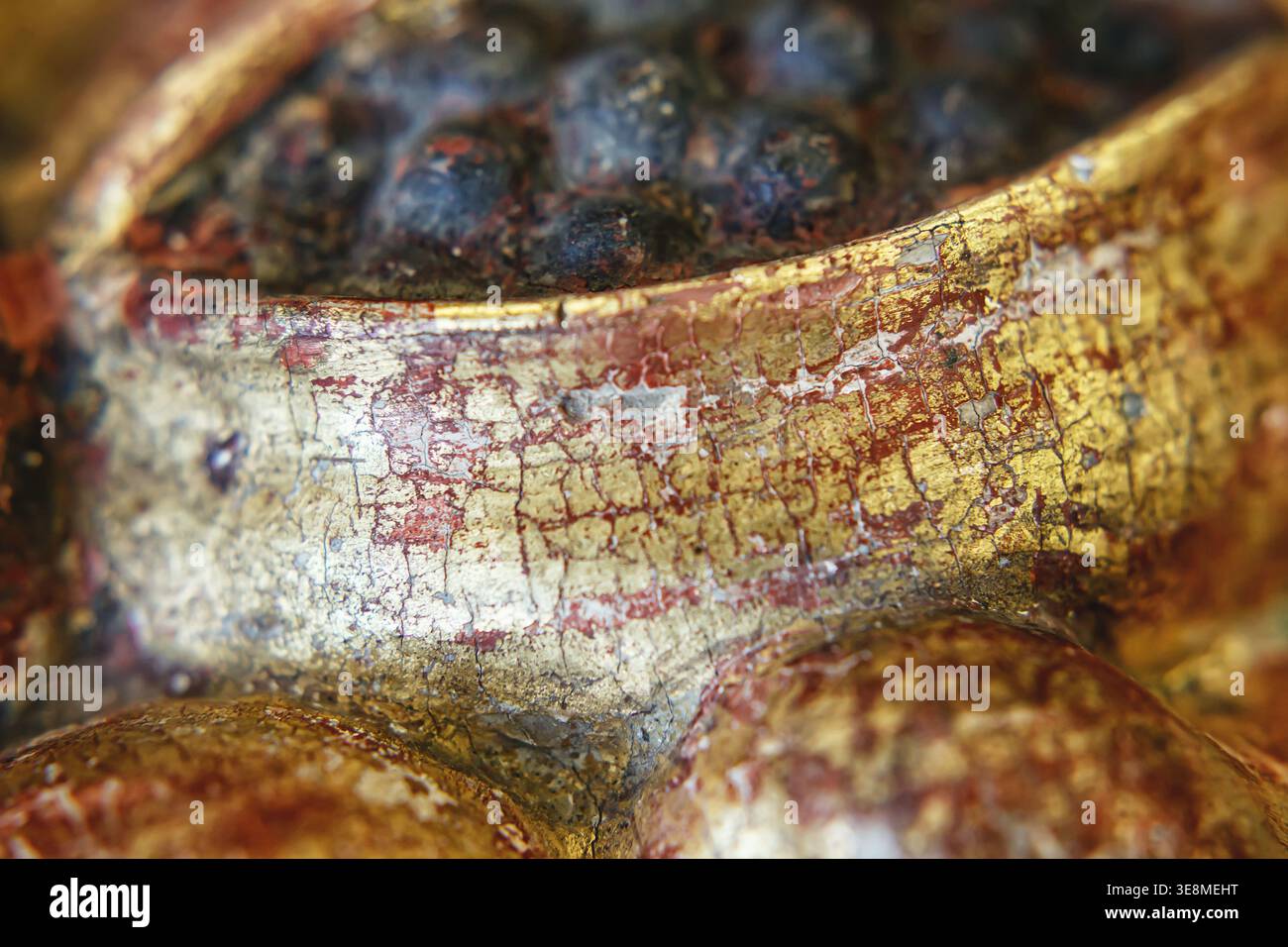 Una vista ravvicinata mostra la trama e i colori di un oggetto decorativo invecchiato nel tempo, rivelando crepe e motivi. Foto Stock