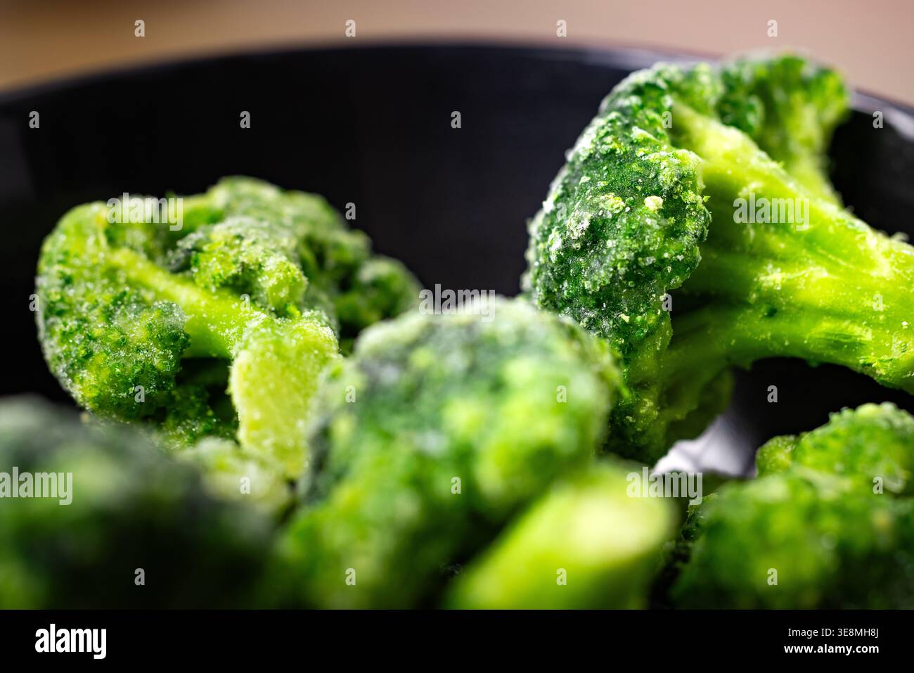 Primo piano di fioretti di broccoli congelati in un recipiente Foto Stock