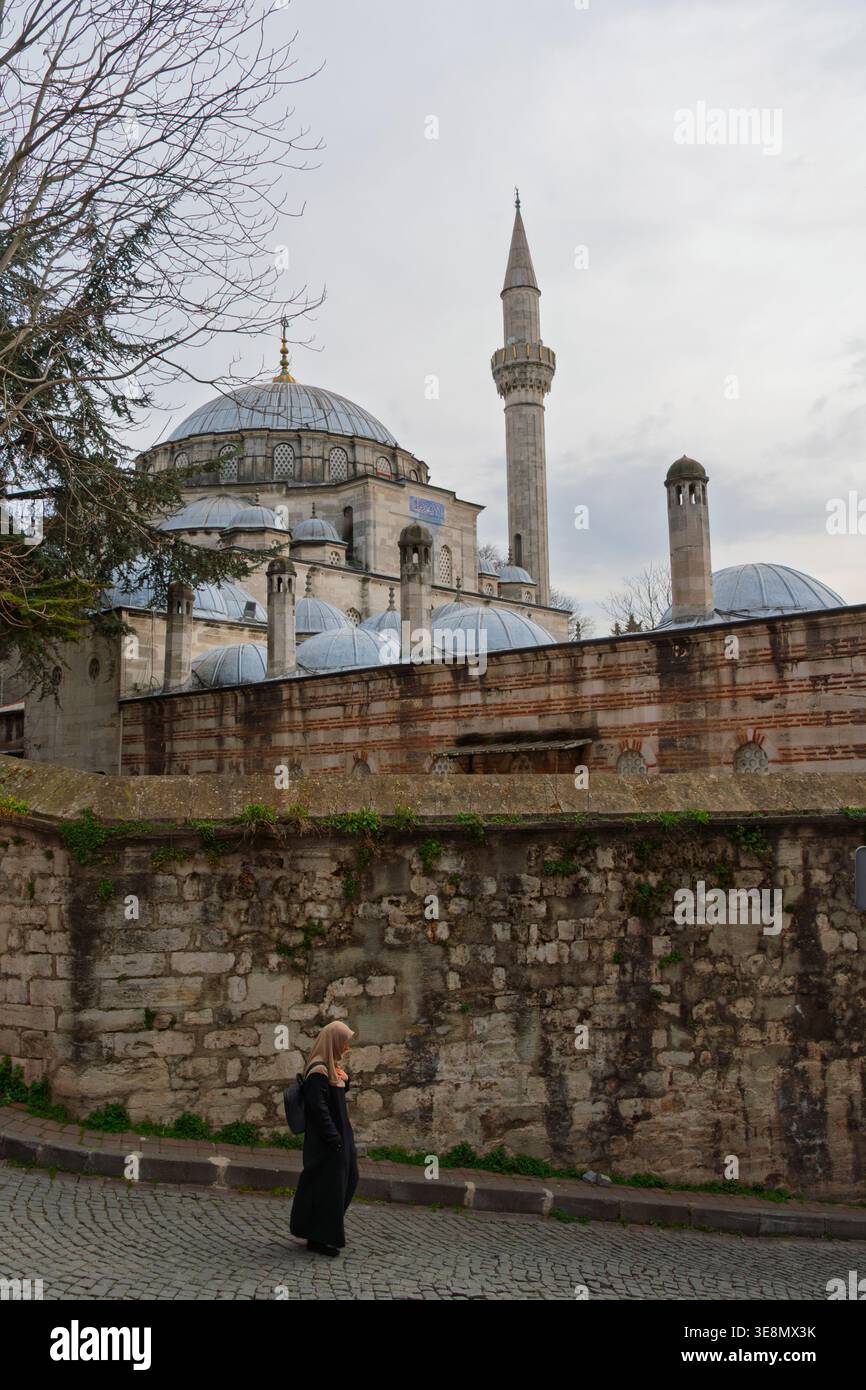 Una persona solitaria cammina per i terreni della Moschea Sokollu Mehmet Pasha, che contiene un raro pezzo di pietra Nera della Mecca. Istanbul, Türkiye. Foto Stock