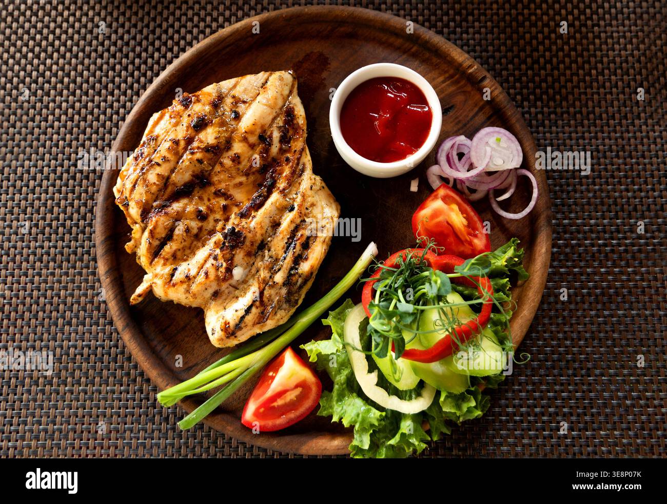 Bistecca di pollo grigliata con verdure e ketchup, primo piano. Bistecca arrosto con insalata. Vista dall'alto. Foto Stock