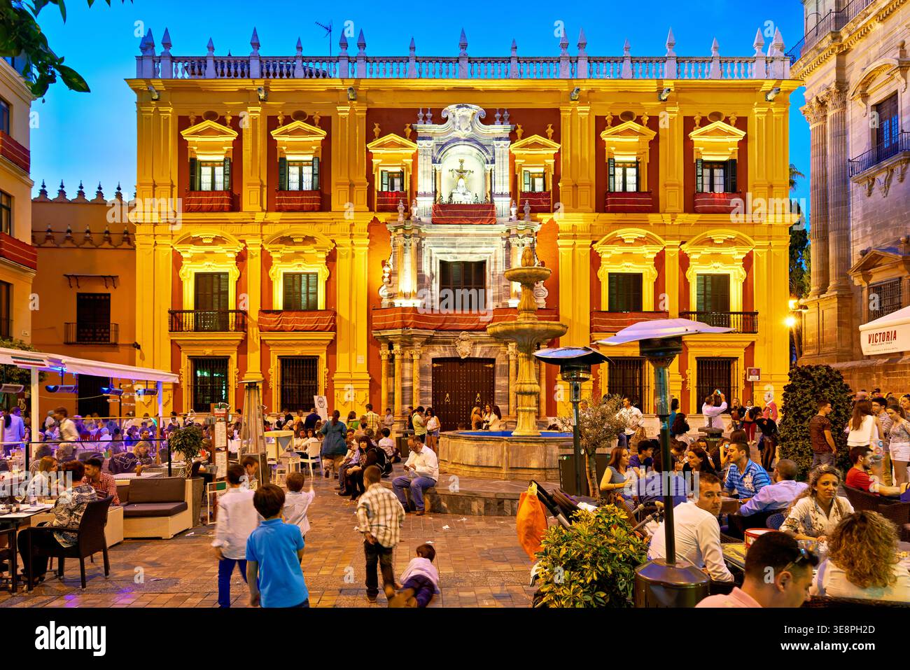 Le persone si godono la serata nel centro storico di Malaga, condividendo cibo e bevande ammirando l'architettura e l'atmosfera vivace. Foto Stock
