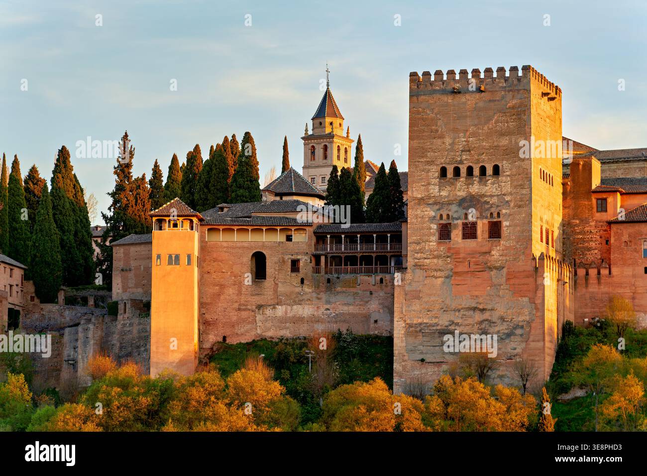 I visitatori ammirano l'Alhambra mentre il sole tramonta dietro le sue torri. Questo sito storico mostra la ricca cultura di Granada in Andalusia. Foto Stock