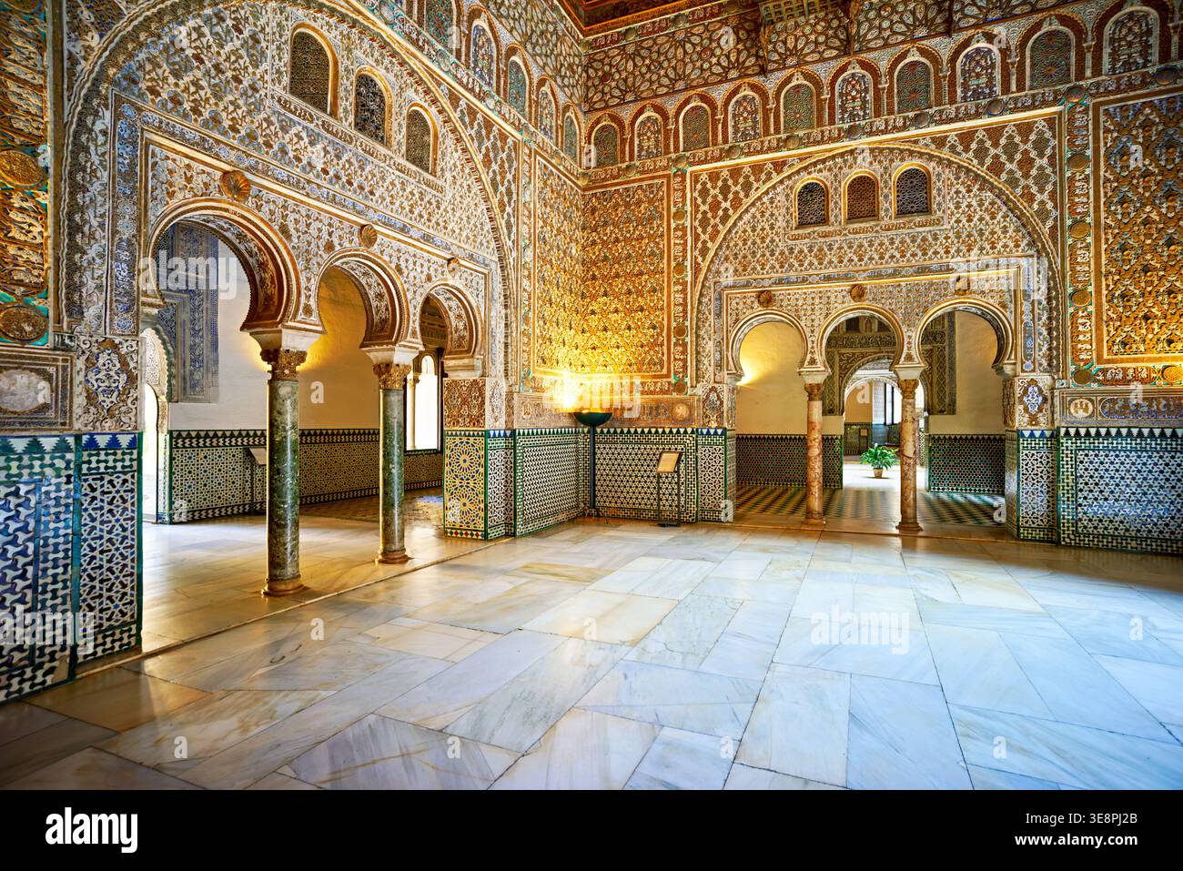 I visitatori camminano attraverso le splendide sale dell'Alcazar di Siviglia. Questo posto mostra un lavoro dettagliato delle piastrelle e una ricca storia in ogni angolo. Foto Stock