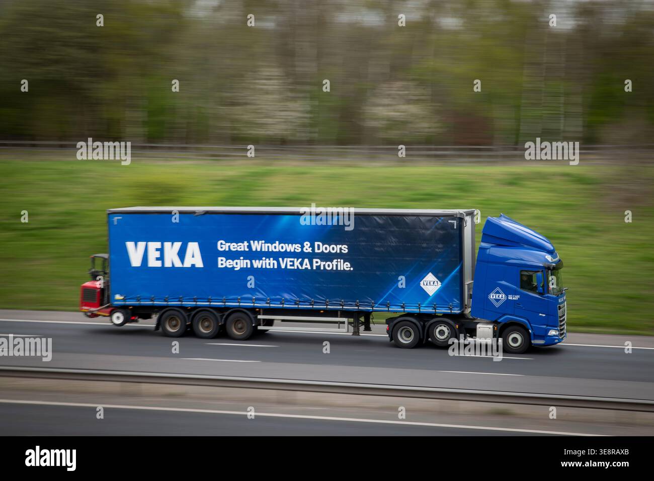 Finestrini e porte VEKA unità motrice DAF XG HGV che tira un rimorchio con telone blu con carrello elevatore a forche, autostrada M65, Altham, Lancashire, Regno Unito Foto Stock
