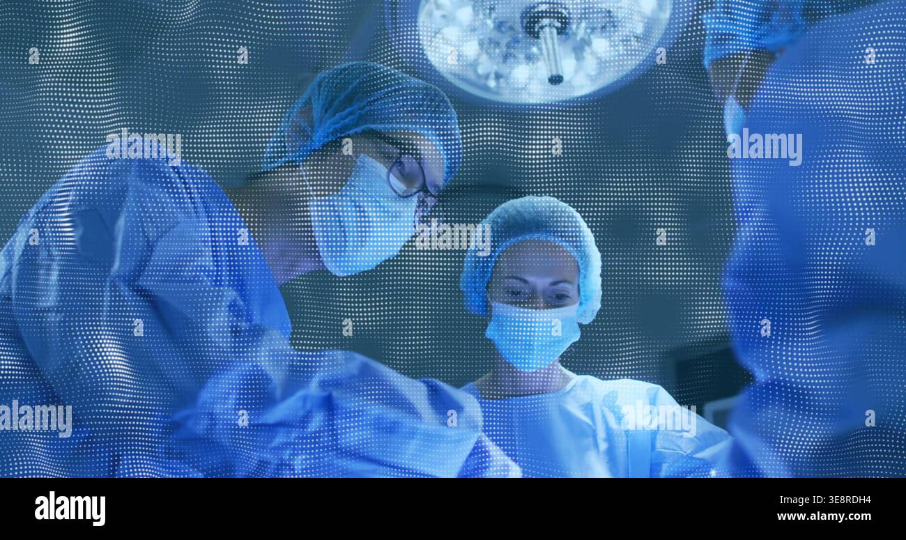 Utilizzo di tre operatori chirurgici che indossano camici appoggiati su un campo sterile all'interno di O, con la luce superiore Foto Stock