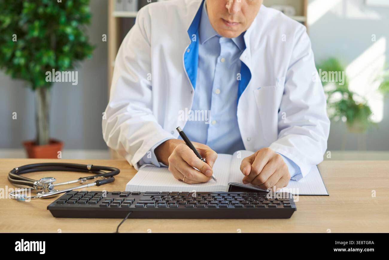 Primo piano di un medico maschile che lavora al computer in clinica Foto Stock