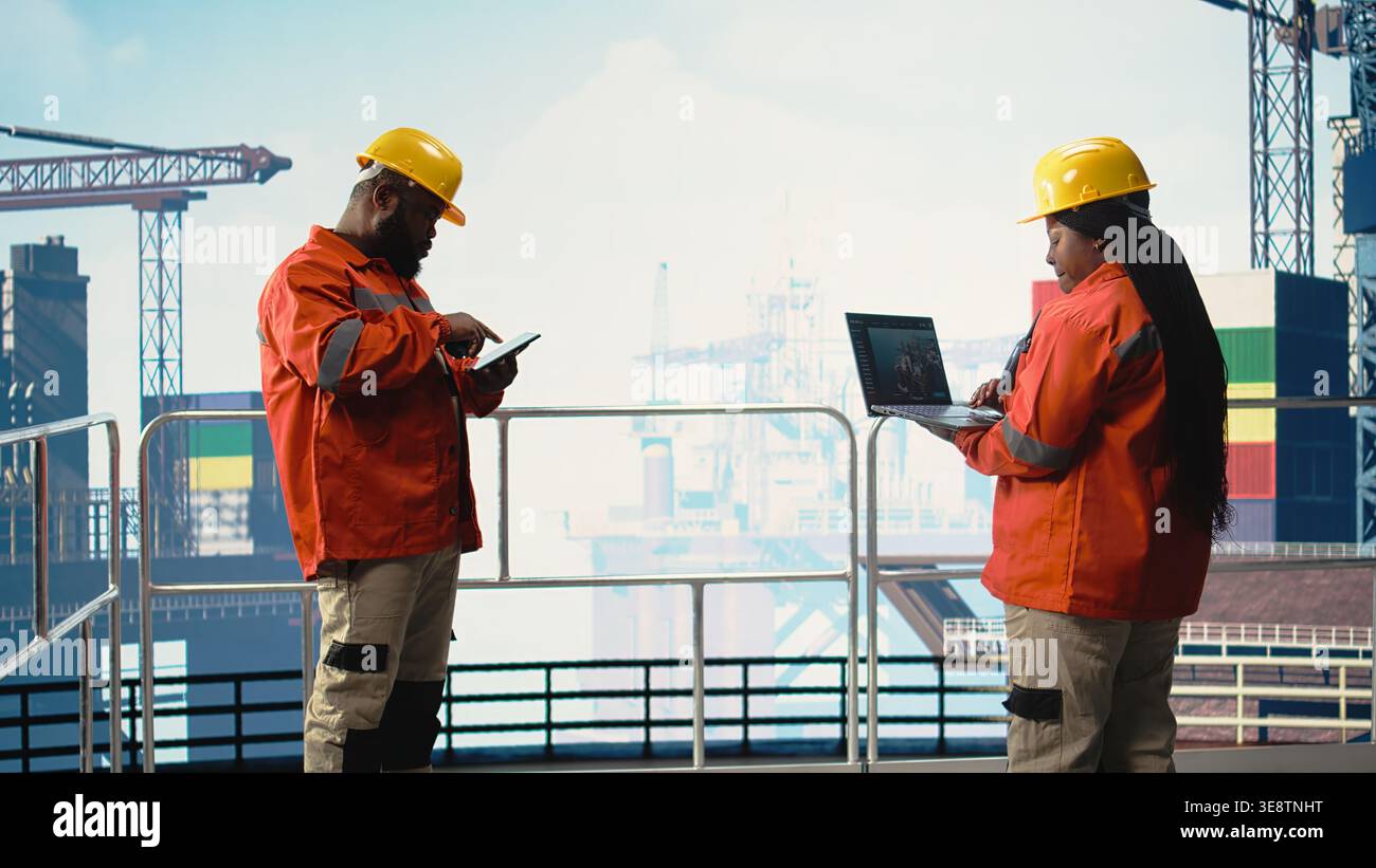 Operaio di attrezzature offshore sul ponte della piattaforma petrolifera per il monitoraggio delle operazioni con laptop software. Esperto di carri di perforazione che esamina le operazioni energetiche utilizzando un notebook, prevede guasti alle apparecchiature, Foto Stock