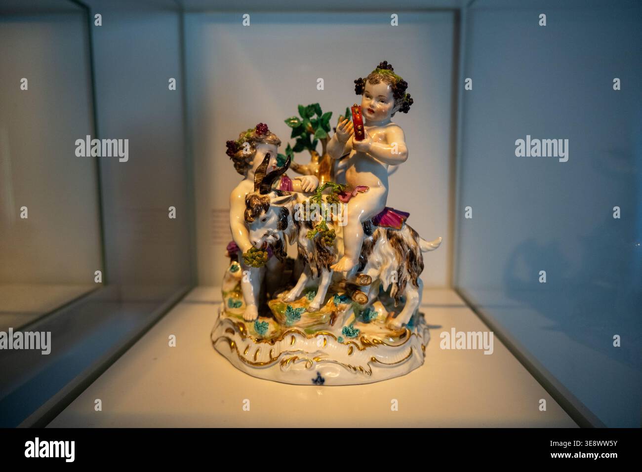 Dusseldorf, Germania - 19 maggio 24: Statuetta in porcellana colorata raffigurante bambini e una capra con dettagli di vite, fotografata in una vetrina presso S. Foto Stock