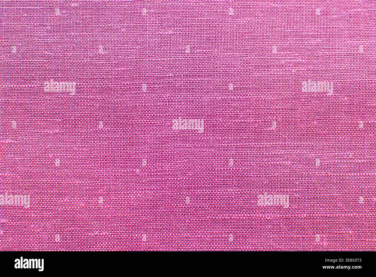 Superficie in tessuto strutturato che forma un motivo geometrico ripetuto in rosa vivace, adatto per l'uso nella progettazione decorativa e grafica. Foto Stock