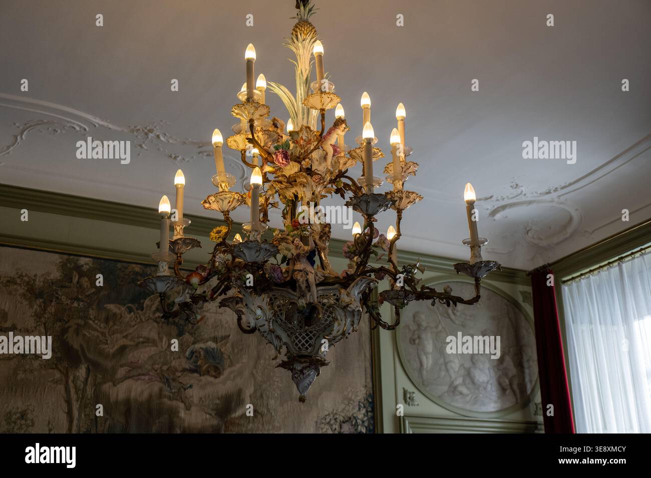 Doorn, Natherlands - 26 maggio 23: Primo piano di un lampadario decorato con lampadine in stile candela e dettagli dorati in una sala storica del museo Huis Doorn, D. Foto Stock