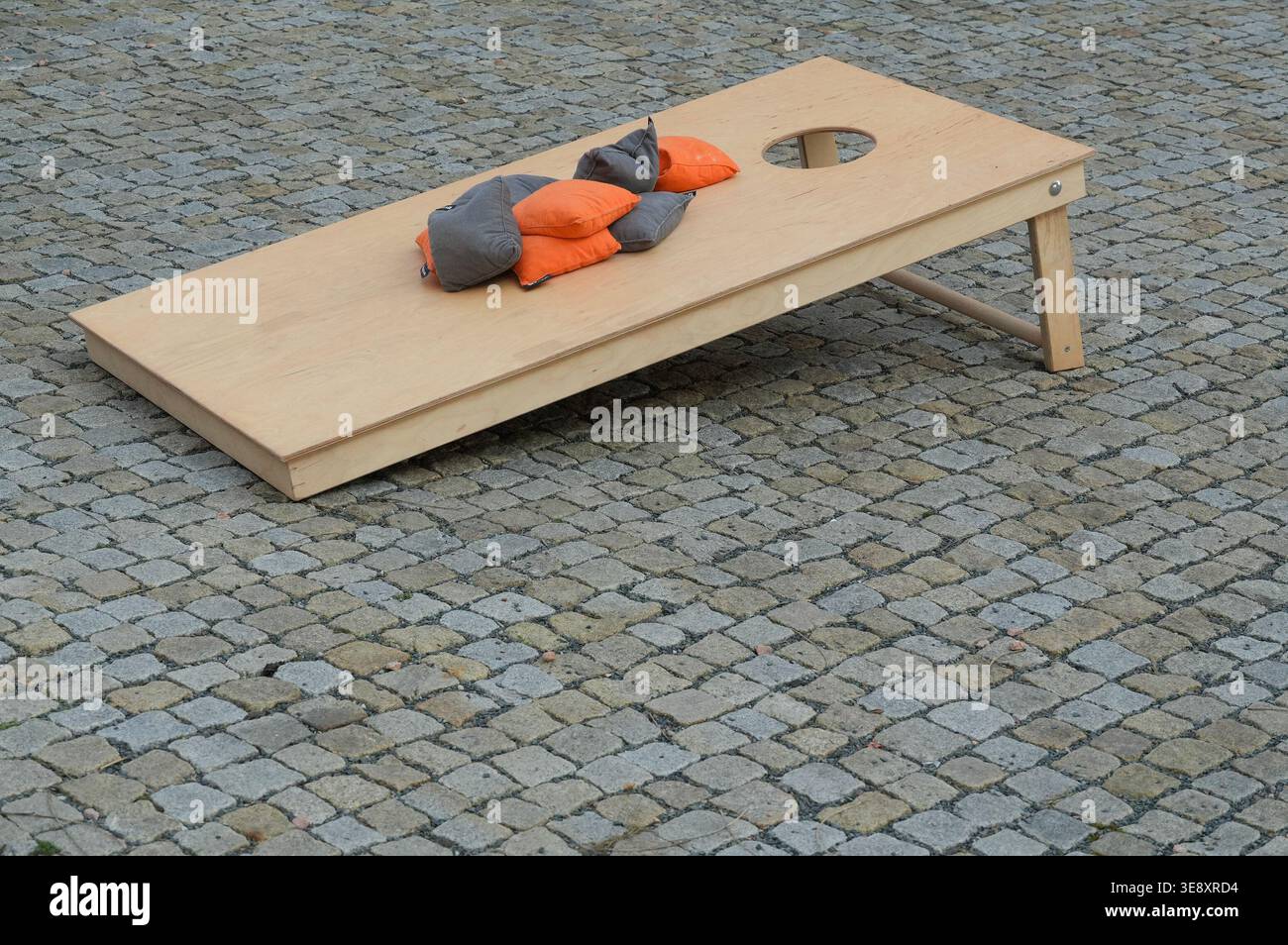 Panca in legno con cuscino arancione sulla strada, primo piano della foto Foto Stock