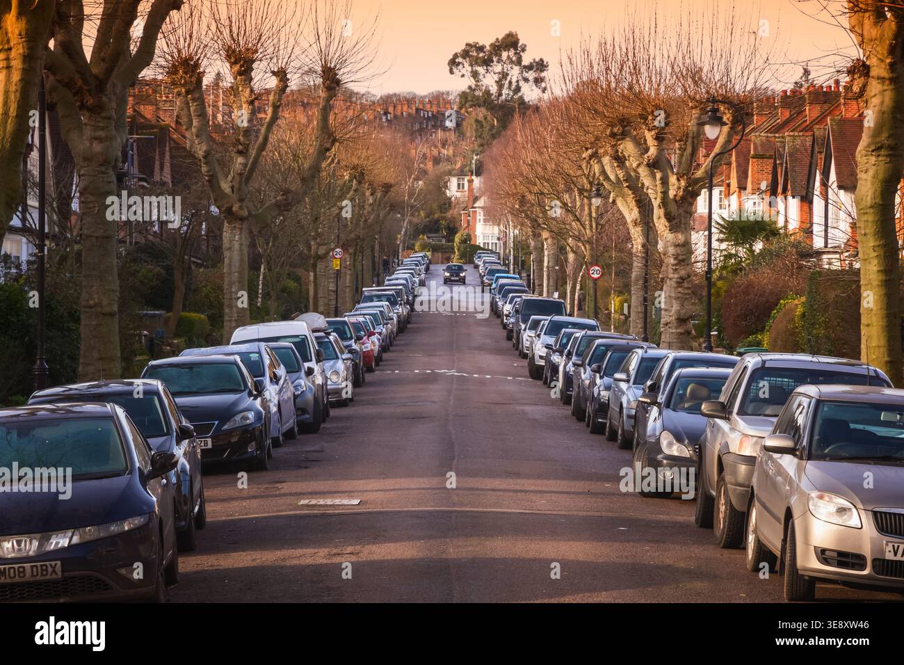 Londra, Regno Unito - 28 gennaio 2026 - tramonto in una strada londinese fiancheggiata da case a schiera e auto parcheggiate su entrambi i lati Foto Stock