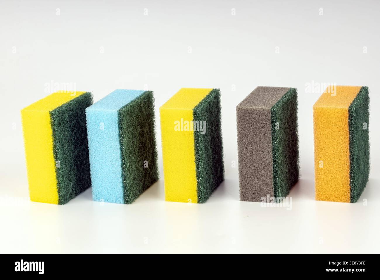 Fotografia di prodotto professionale che mostra cinque spugne da cucina a due lati con superfici in schiuma colorata vivace e spugnette verdi resistenti. Il colle Foto Stock