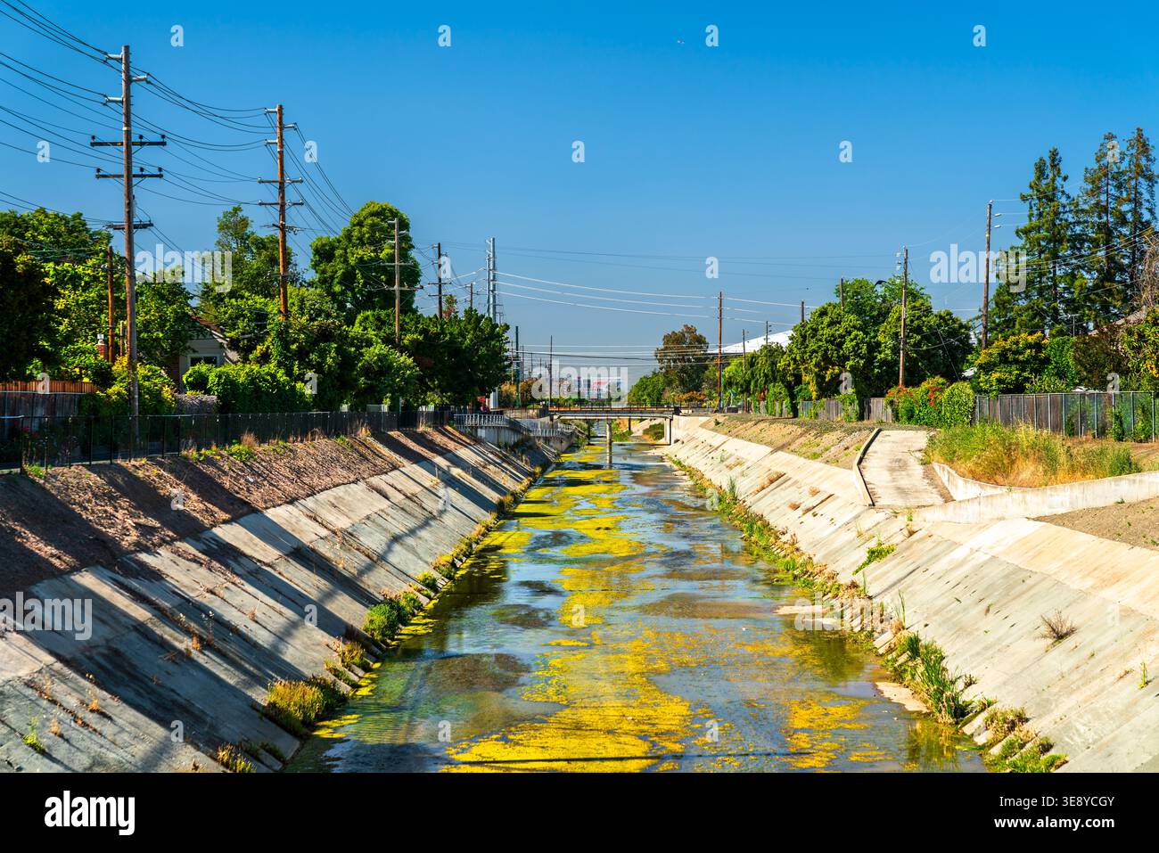 Vista del canale San Tomas Aquino Creek a Santa Clara, Silicon Valley, California, con fodera in cemento e alghe sotto un cielo soleggiato. Foto Stock