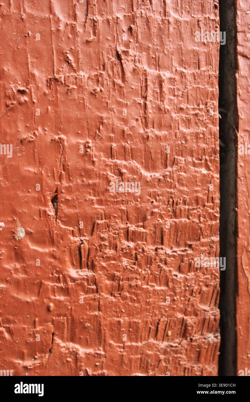 Una vista ravvicinata rivela la consistenza di una superficie in legno che è stata intemprata nel tempo. La vernice mostra segni di sbiadimento e scheggiature, evidenziando Foto Stock