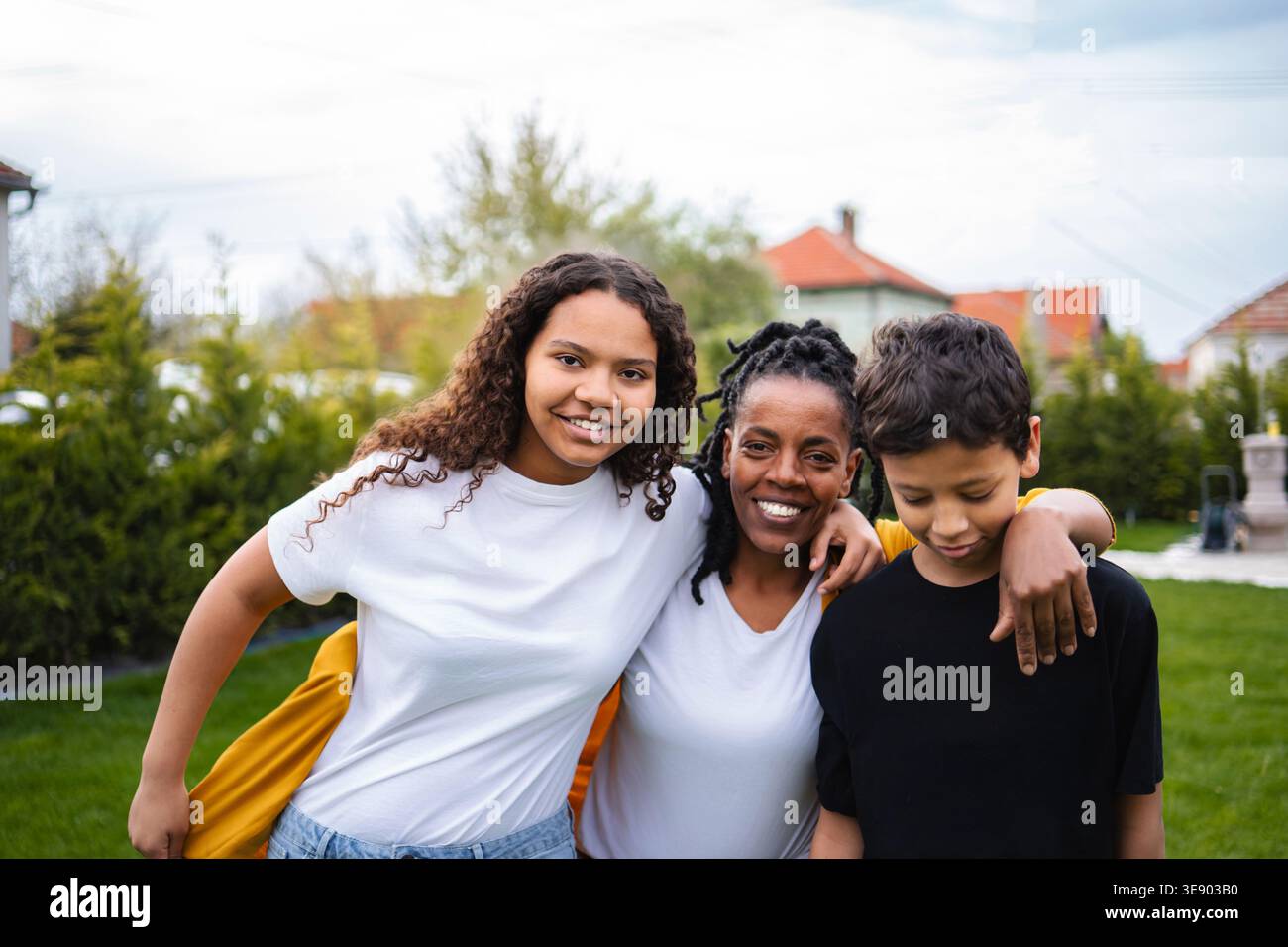 Madre e figli ridono all'aperto condividendo momenti felici in famiglia Foto Stock