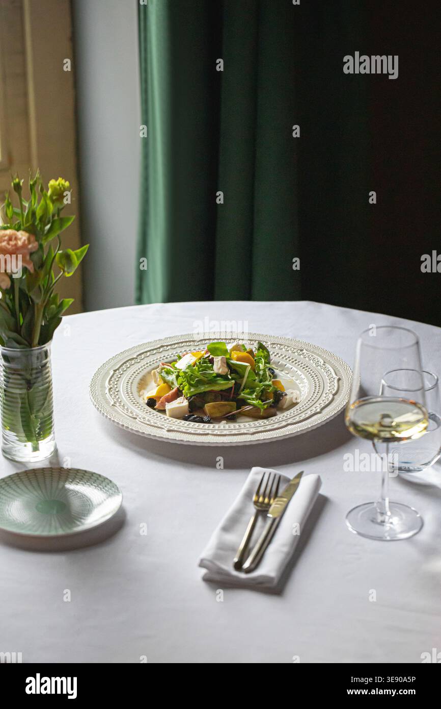 Elegante insalata con vino sul tavolo del ristorante Foto Stock