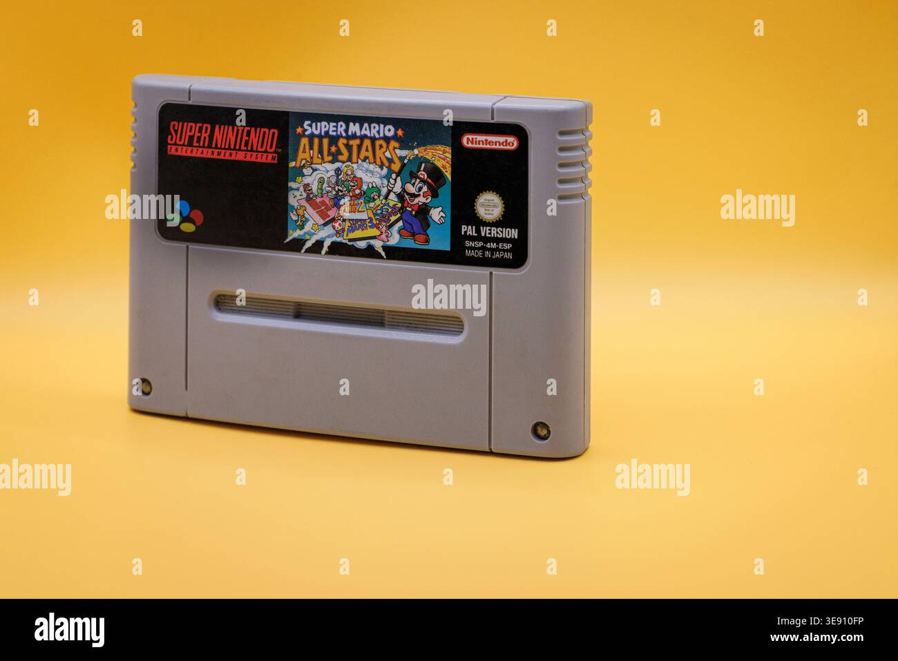 OURENSE, SPAGNA - 5 APRILE 2026: Cartuccia di gioco Super Mario All Stars Close-up, media di gioco classici anni '1990 su sfondo giallo Foto Stock
