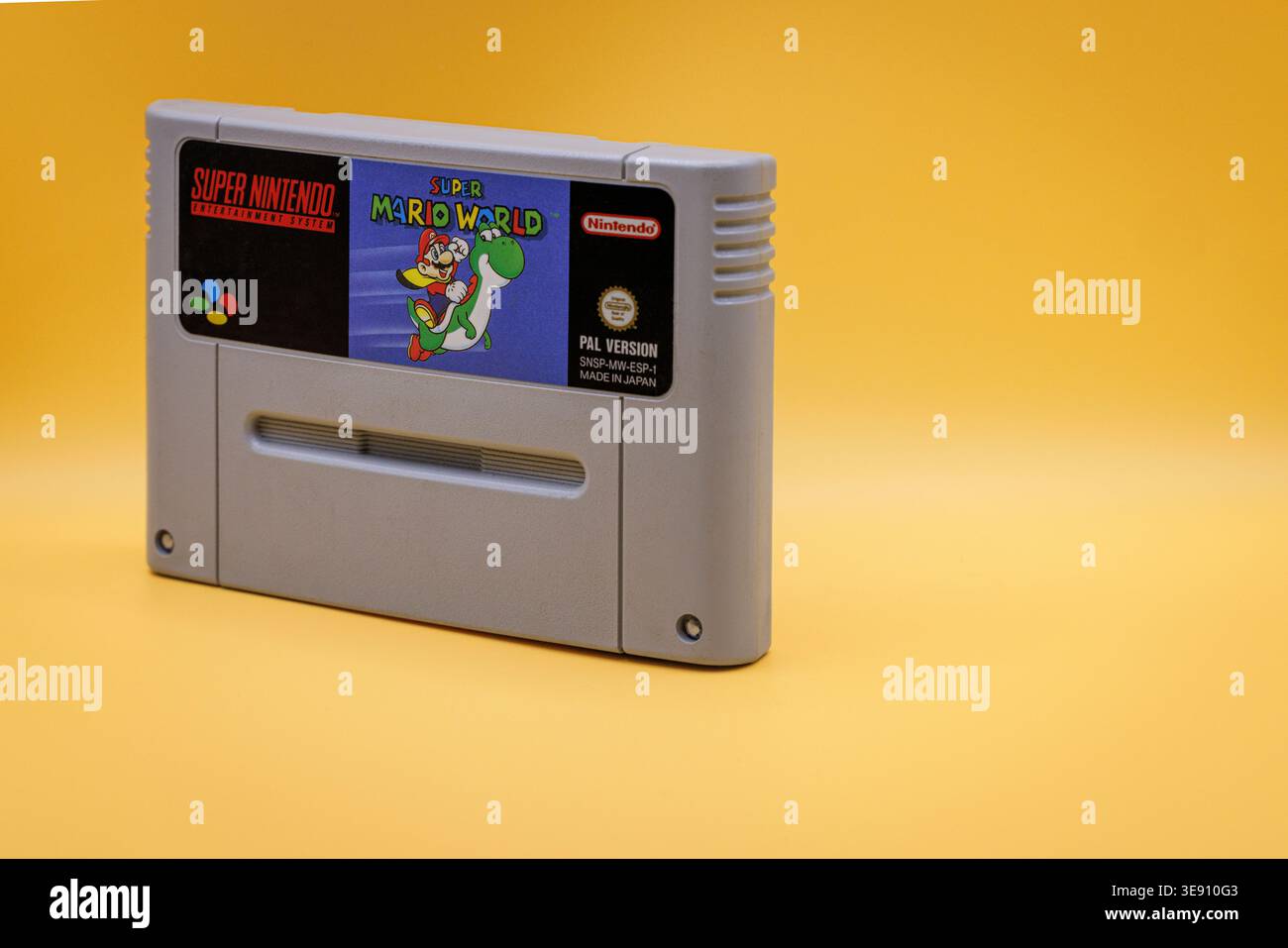 OURENSE, SPAGNA - 5 APRILE 2026: Cartuccia di gioco Super Mario World Close-up, media di gioco classici anni '1990 su sfondo giallo Foto Stock
