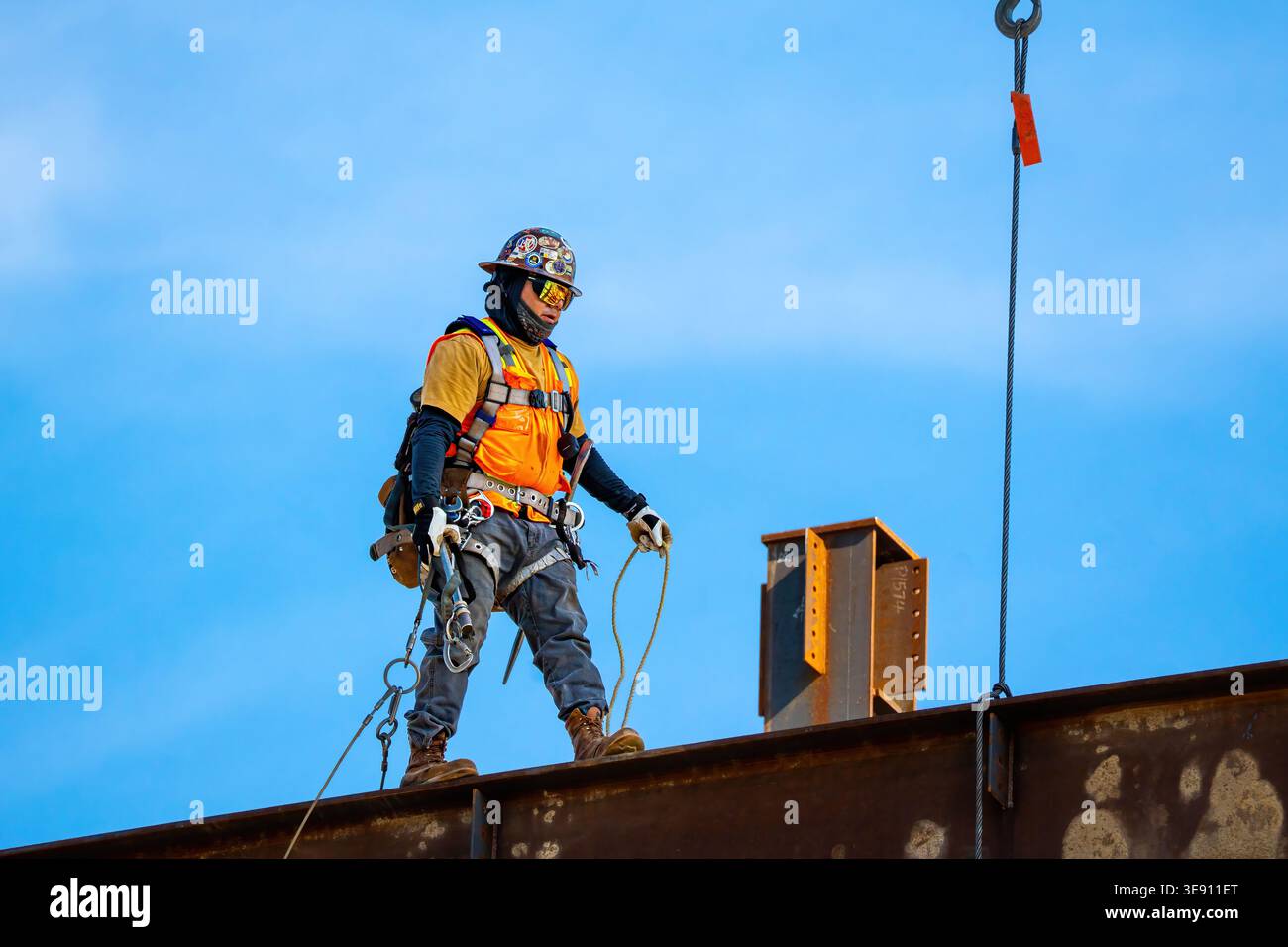 Lavoratore d'acciaio in piedi su una trave d'acciaio durante la costruzione di un progetto di costruzione nel centro di Raleigh, illustrando manodopera qualificata e sviluppo urbano. Foto Stock