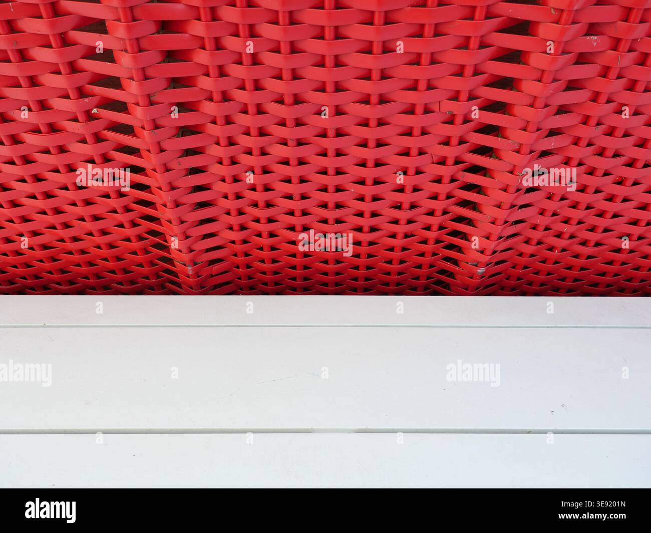 Motivo in vimini di plastica rossa di una sedia da spiaggia che forma una texture geometrica. Copyspace. Foto Stock