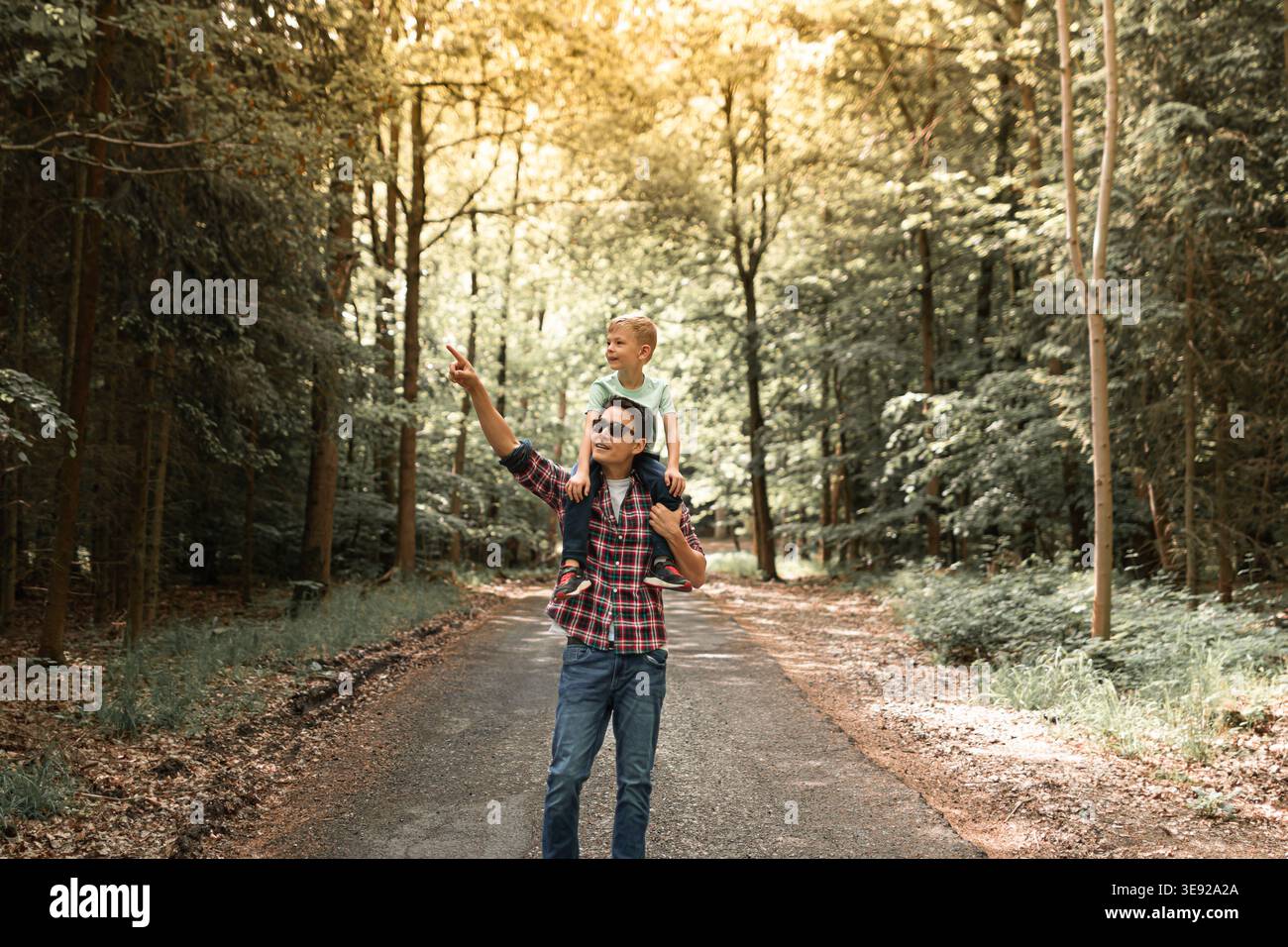 Padre e figlio camminano insieme nella foresta esplorando la natura. Il genitore passa del tempo con il bambino. Papà e figlio. Buona festa del papà. Foto Stock