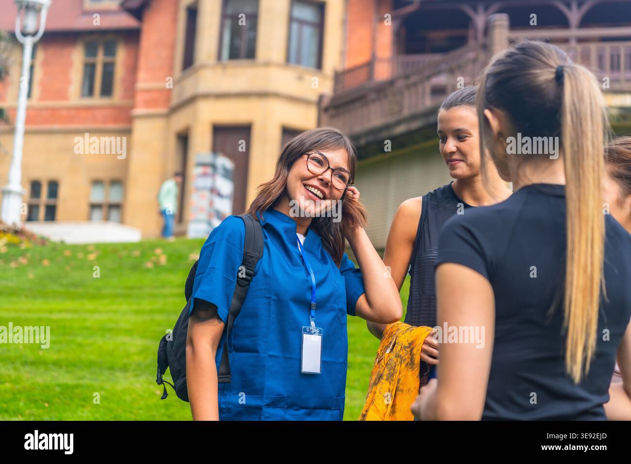 Gruppo di giovani donne che sorridono e parlano nel campus universitario Foto Stock