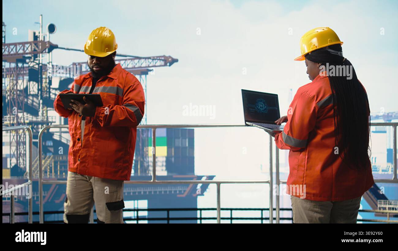 Progetta su piattaforme offshore utilizzando software di intelligenza artificiale su laptop per ottimizzare le operazioni di perforazione. Colleghi di lavoro di squadra che monitorano l'attività di chiatta utilizzando la tecnologia di intelligenza artificiale, Foto Stock