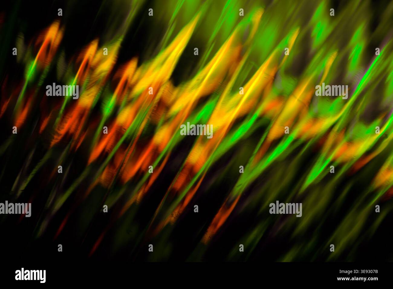 Flusso di luce ondulata astratta con colori verde e arancione luminosi per una texture dinamica e uniforme Foto Stock
