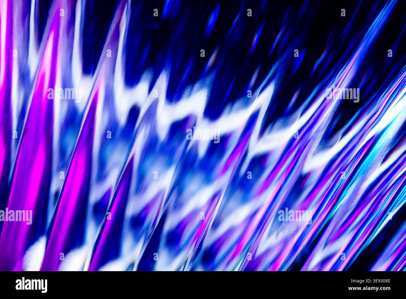 Onde di luce blu e viola su una superficie metallica testurizzata con increspature riflettenti Foto Stock