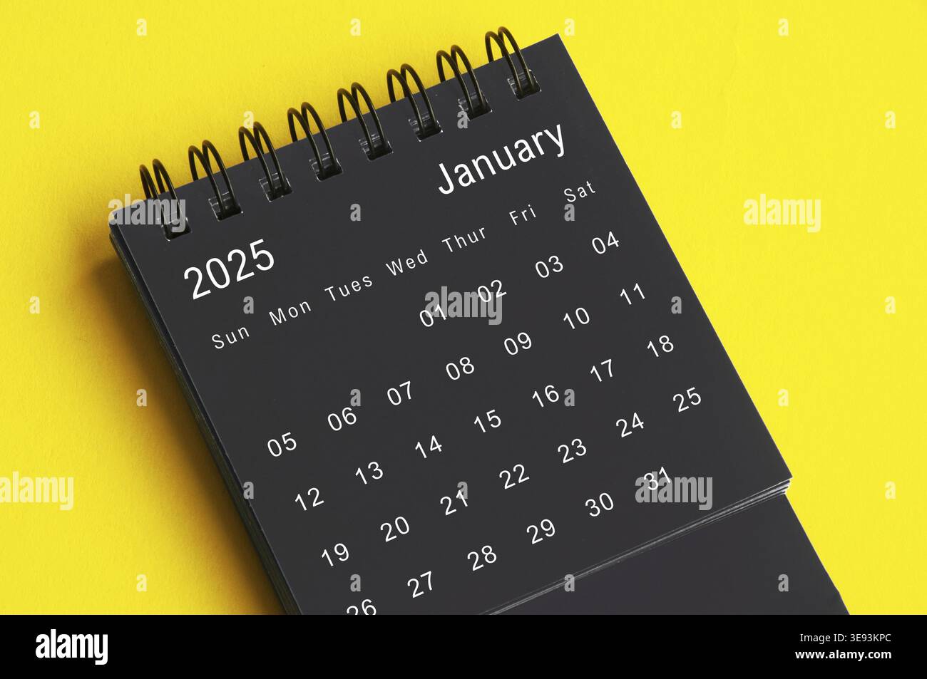 Calendario da tavolo in bianco e nero gennaio 2025 su sfondo giallo. Concetto di calendario Foto Stock