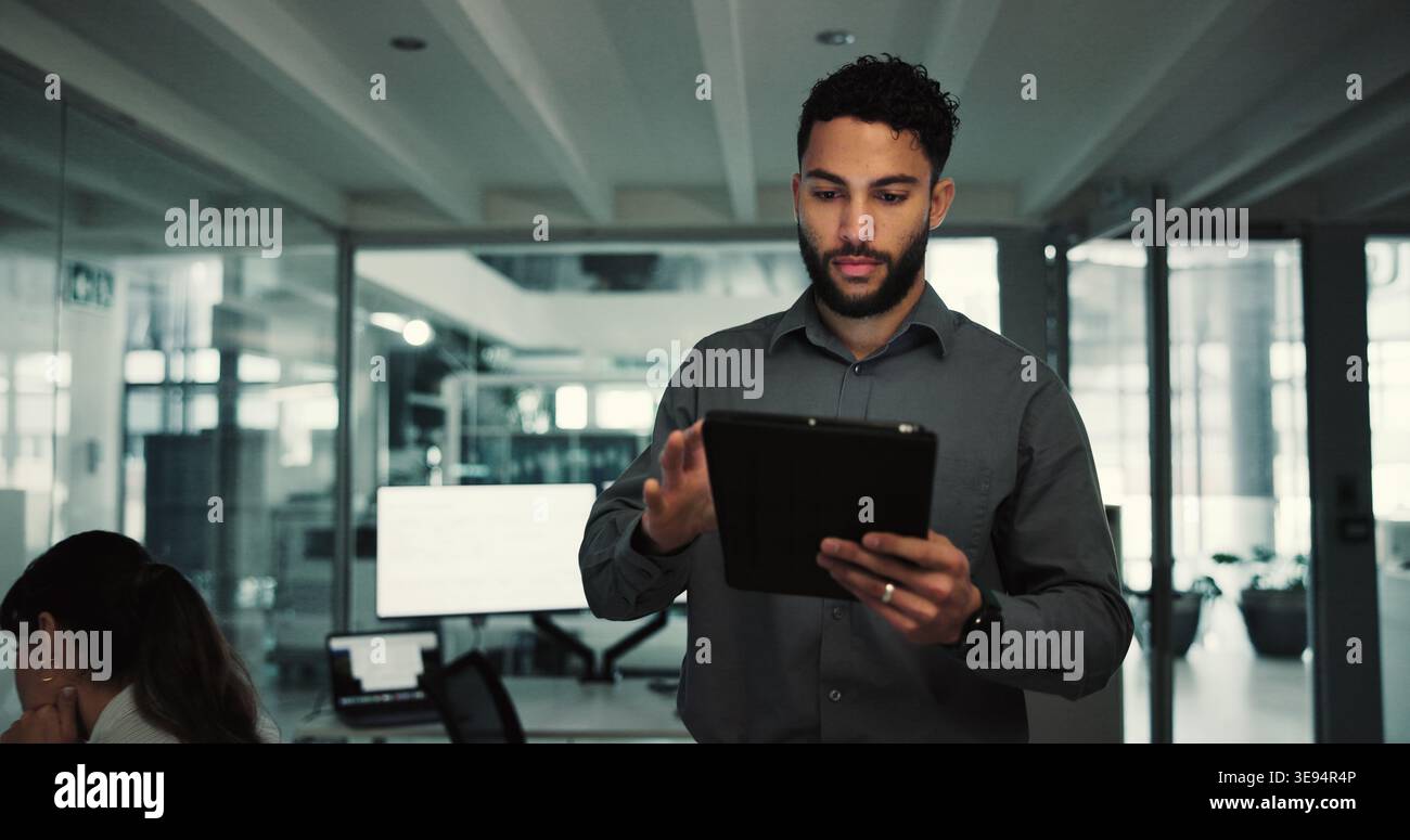Uomo, programmatore e digitazione con tablet in ufficio per ricerche, aggiornamento dei server e risoluzione dei problemi. Persona maschile, scorrimento e digitale per la programmazione Foto Stock