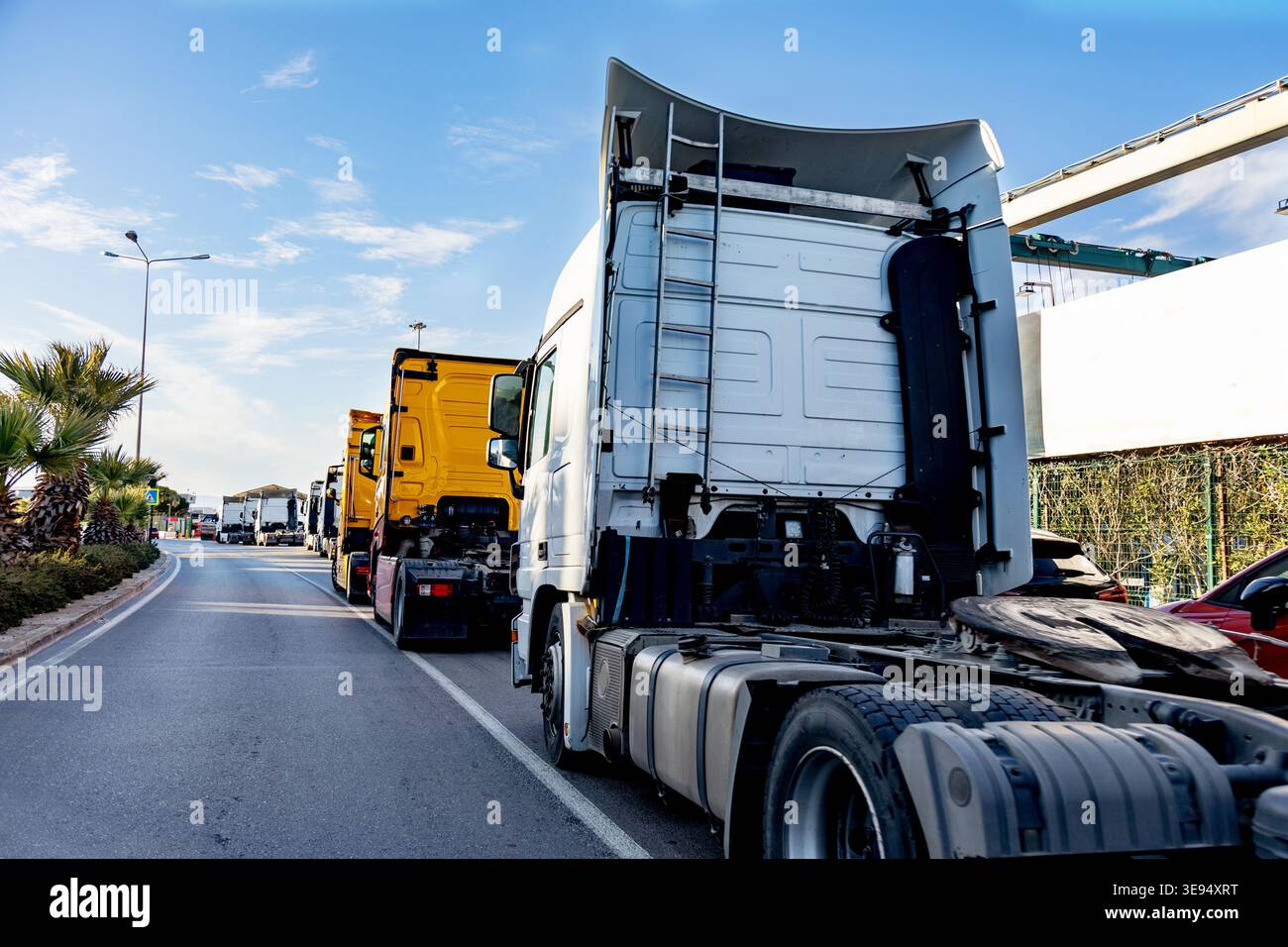 Lunga coda di camion commerciali in attesa in coda su un'autostrada Foto Stock