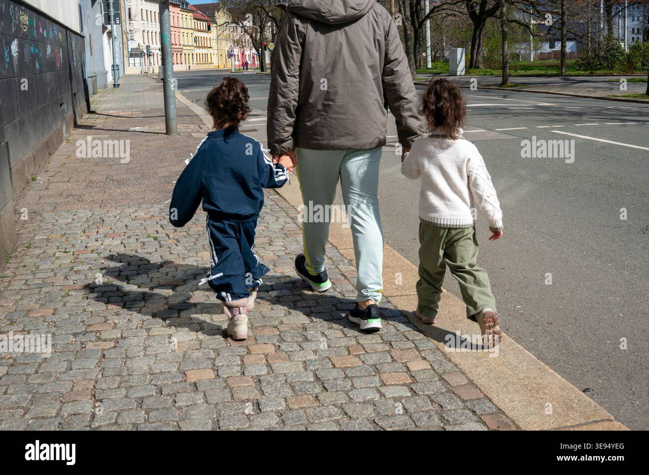 Padre single con due ragazze in città sul marciapiede Foto Stock