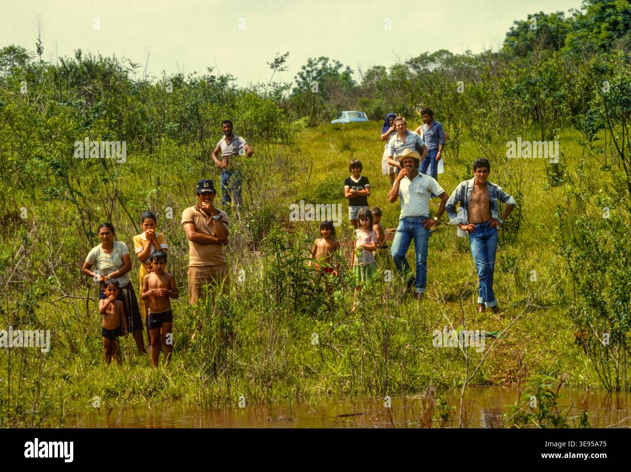 Le popolazioni locali sfollate dalle loro case e dalla loro terra, con poco o nessun risarcimento, vengono a vedere i livelli crescenti delle acque della diga di Itaipu hydo, ottobre 1982. In tutto circa 65.000 persone sono state sfollate. Foto Stock
